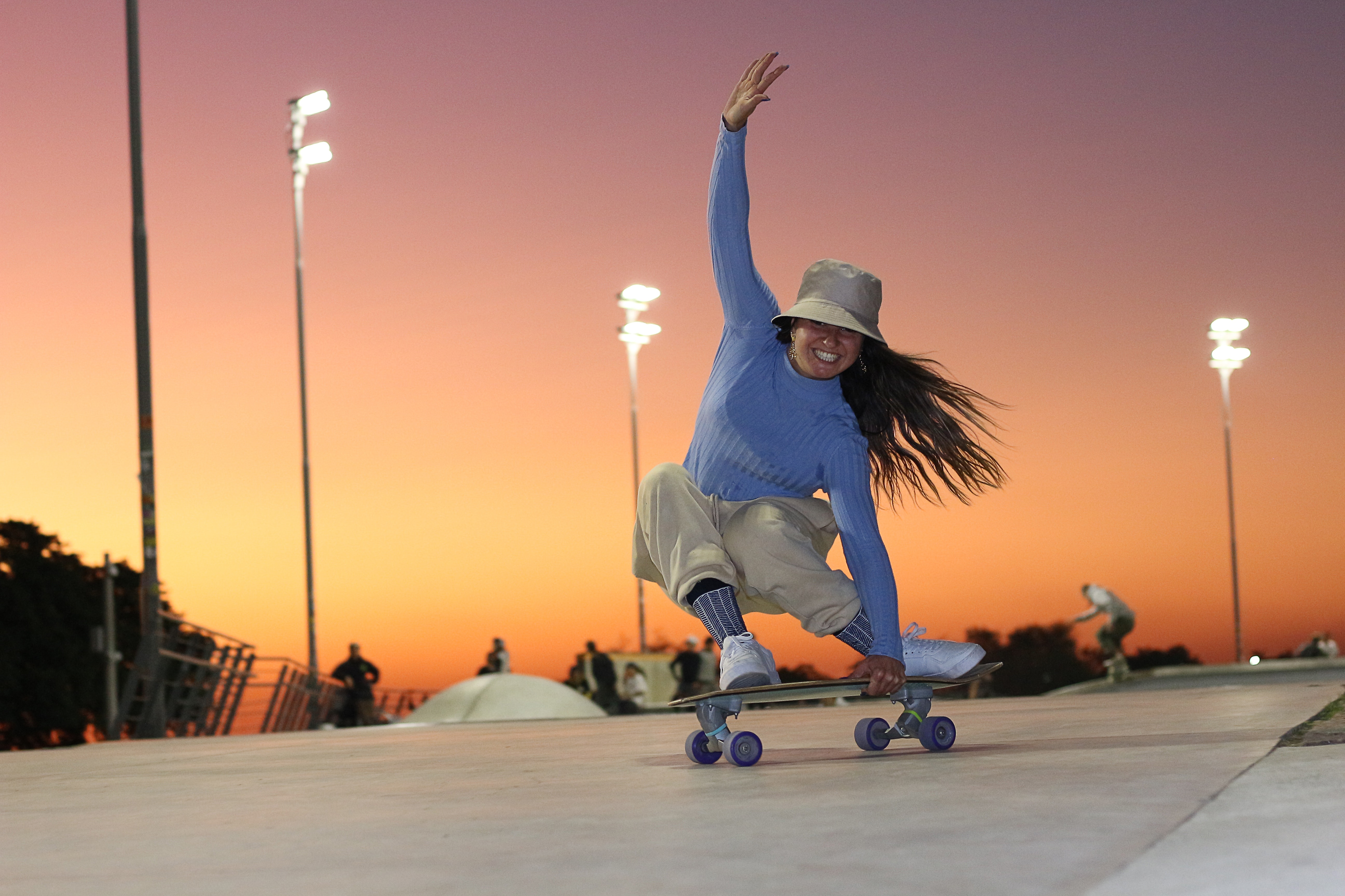 woman skateboarding on ramp at sunset