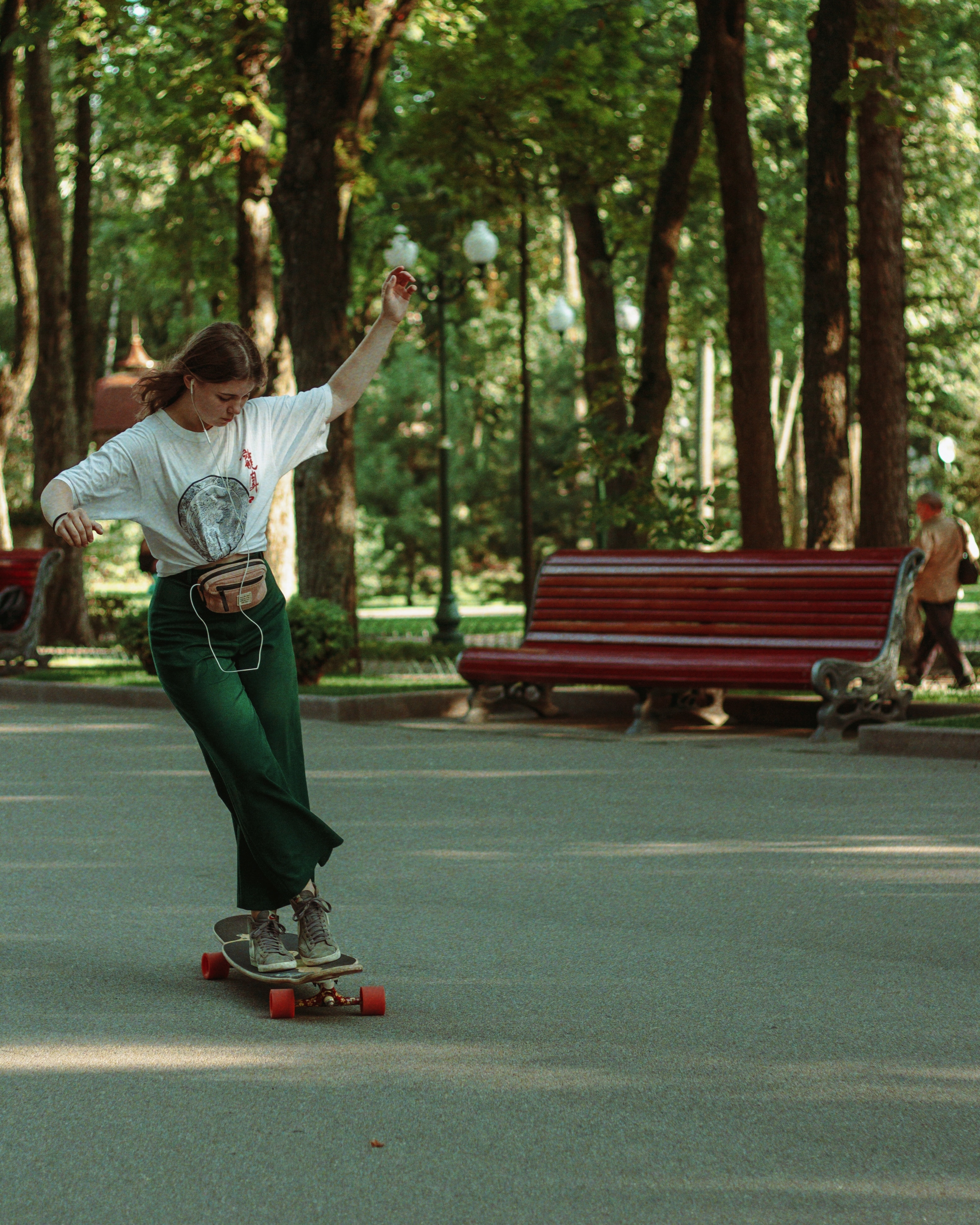 woman skateboarding in front of trees